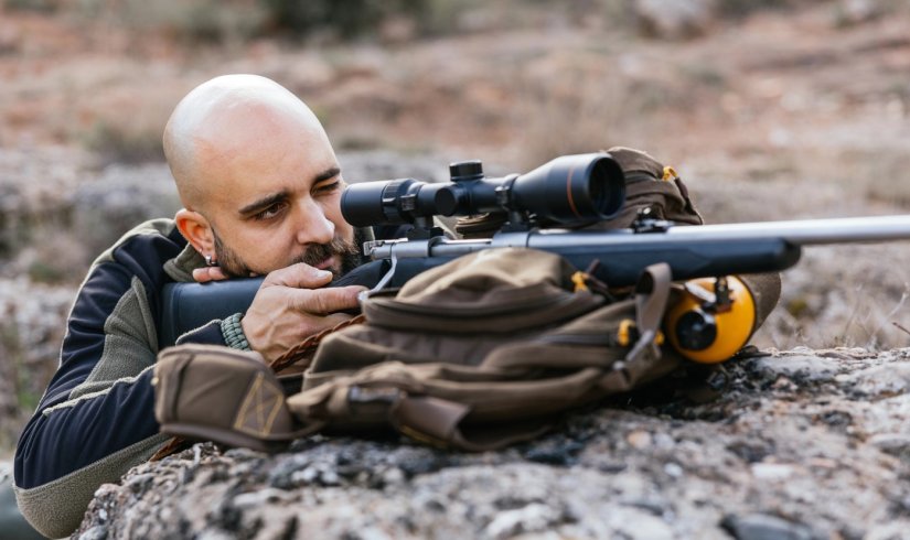 Posición de tiro con rifle apoyado en mochila para mayor estabilidad