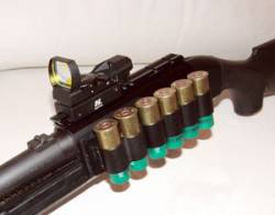 Escopeta Benelli M3 Super 90 con montura especial para visor NcStar de tipo holográfico y cartuchera con munición del calibre 12