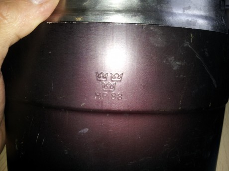 Este en buenas condiciones y tiene los marcajes originales, es de acero. El quemador tiene la tapa rajada 00