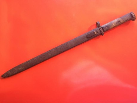 Mide 52 cm en total, 39 el filo. Tiene las cachas de madera y la vaina es de metal. Tiene el filo hacia 12