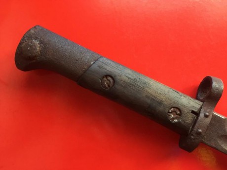 Mide 52 cm en total, 39 el filo. Tiene las cachas de madera y la vaina es de metal. Tiene el filo hacia 21