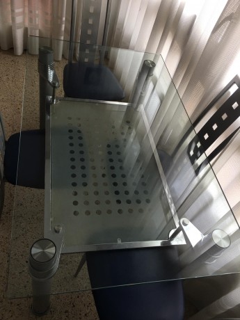 Mesa de cristal y su juego de cuatro sillas de diseño, prácticamente nuevas,por 250 euros,se encuentra 11