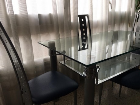 Mesa de cristal y su juego de cuatro sillas de diseño, prácticamente nuevas,por 250 euros,se encuentra 21
