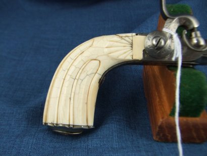 Esta es una pistola monotiro de percusion, calibre aprox .50 con la culata de marfil y fabricada en Belgica. 21